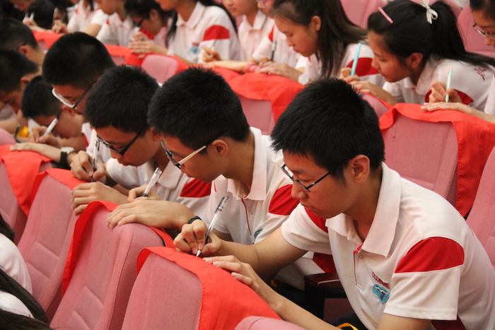 6同学们在取下的红领巾上认真书写自己的誓言与承诺.JPG
